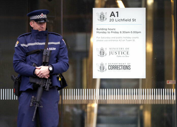 New Zealand Mosque Attacks A armed police office stands guard Friday outside the entrance to the High Court in Christchurch, New Zealand. Photo: Mark Baker / Associated Press