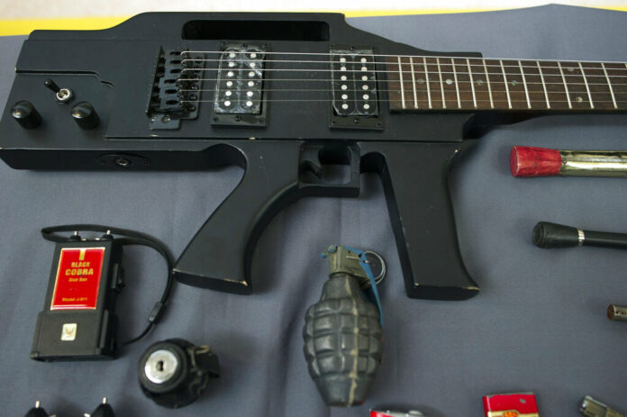 Items, prohibited on passenger airlines, and confiscated from passengers by Transportation Security Administration (TSA) officers, is displayed at Dulles International Airport in Dulles, Va., Tuesday, March 26, 2019. The items include a guitar shaped like a semi-automatic rifle, an inert grenade, and a stun gun. Photo: Cliff Owen / Associated Press