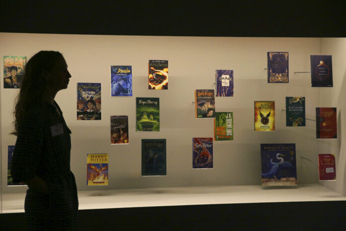 In this Wednesday Oct. 18, 2017 file photo, a member of British Library staff poses for a picture with Harry Potter books published in several languages at the 