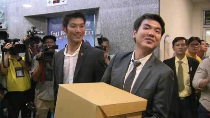 Future Forward Party leader Thanathorn Juangroongruamgkit, left, and party secretary general Piyabutr Saengkanokkul, right, at the Election Commission on Tuesday. Photo: Matichon