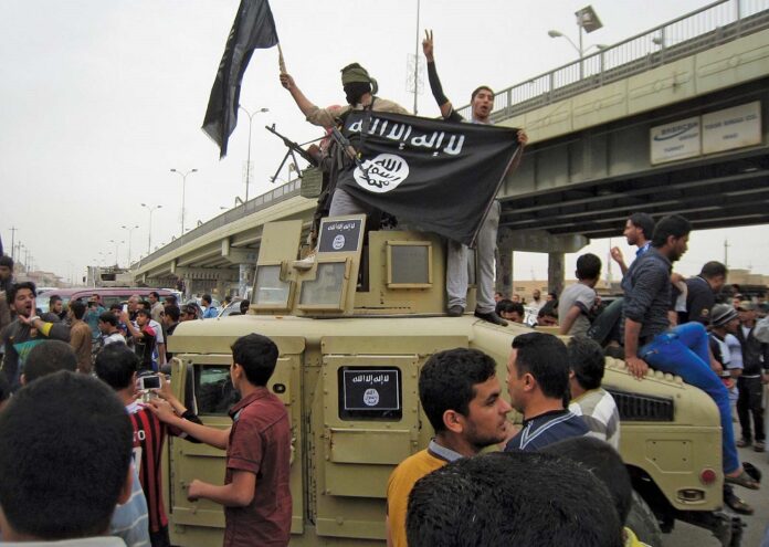 Islamic State fighters displaying the black flag of al-Qaeda and other Islamic extremist movements on a captured Iraqi military vehicle in Al-Fallūjah in March 2014. Image: Associated Press.