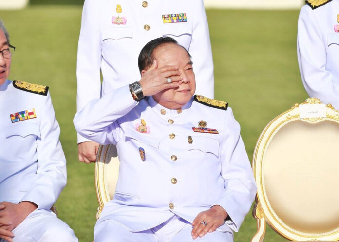 Gen. Prawit Wongsuwan raises a hand to shield his eyes from sunlight Dec. 4, 2017, in a cabinet photoshoot at the Government House.
