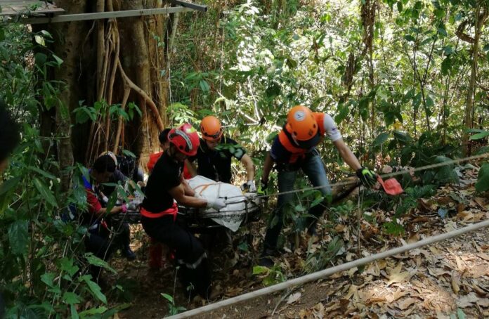 Rescue workers move the body of a Canadian tourist who died Saturday after falling from a zipline in Chiang Mai province.