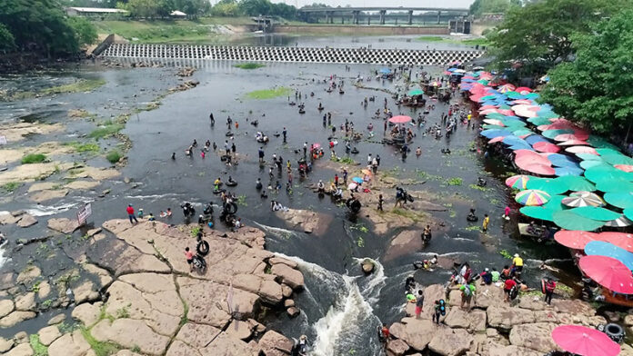 People cool off in the Nong Wai Dyke in Khon Kaen on Saturday.