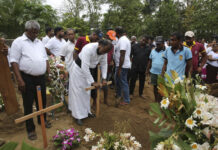 Security Heavy as Sri Lanka Warns of Further Attacks Father Niroshan Perera places a cross during the funeral service of Dhami Brandy, 13, who was killed during Easter Sunday's bomb blast at St. Sebastian Church, in Negombo, Sri Lanka Thursday, April 25, 2019. Photo: Manish Swarup / AP