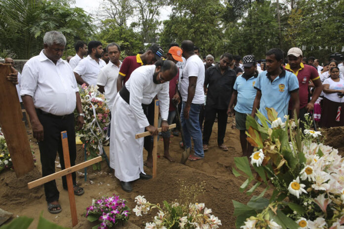 Father Niroshan Perera places a cross during the funeral service of Dhami Brandy, 13, who was killed during Easter Sunday's bomb blast at St. Sebastian Church, in Negombo, Sri Lanka Thursday, April 25, 2019. Photo: Manish Swarup / AP