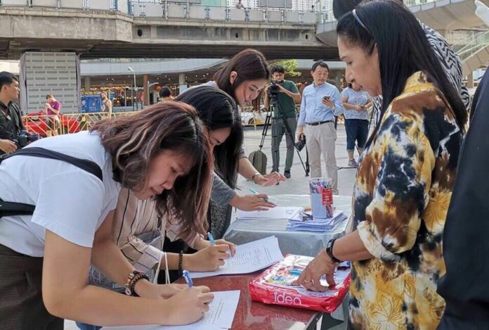 People sign up a petition to oust the Election Commission Friday in Bangkok.