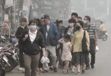 Toxic Smog Turns Thousands of Tourists Away From North People are seen wearing face masks as they walk Monday in Chiang Rai’s Mae Sai district.