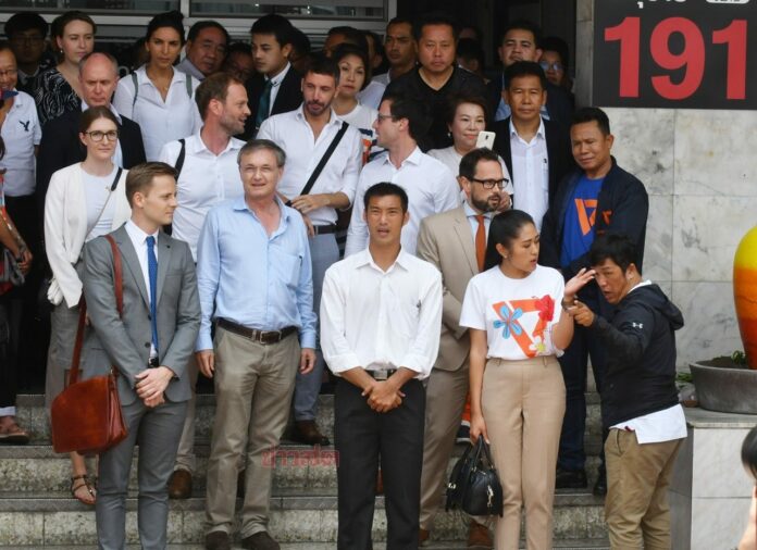 Future Forward Party leader Thanathorn Juangroongruangkit pose for photos with foreign diplomats at Pathumwan Police Station in Bangkok on April 6, 2019.