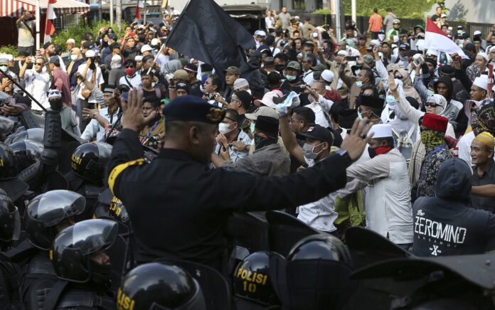 Indonesian police officers block supporters of Indonesian presidential candidate Prabowo Subianto during a rally outside the Elections Supervisory Agency (Bawaslu) building in Jakarta, Indonesia, Tuesday, May 21, 2019. (AP Photo/Achmad Ibrahim)
