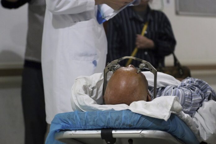 A stereotactic device presses into the head of a brain surgery patient at Ruijin Hospital's functional neurosurgery center in Shanghai, China on Monday, Oct. 29, 2018. (AP Photo/Erika Kinetz)