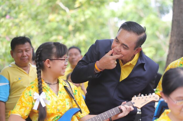 Junta chairman Prayuth Chan-ocha gestures at a young musician on May 15, 2019, during a visit to Khlong Toei district in Bangkok.
