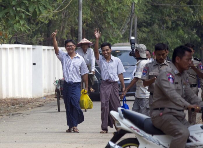 Reuters journalists Wa Lone, left, and Kyaw She Oo, third left, wave as they walk out from Insein Prison after being released in Yangon, Myanmar Tuesday, May 7, 2019. (AP Photo/Thein Zaw)