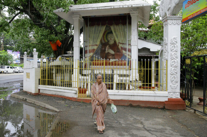 An elderly Sri Lankan Muslim woman walks past a Buddhist shrine in Colombo, Sri Lanka, Thursday, May 2, 2019. Photo: Eranga Jayawardena / AP