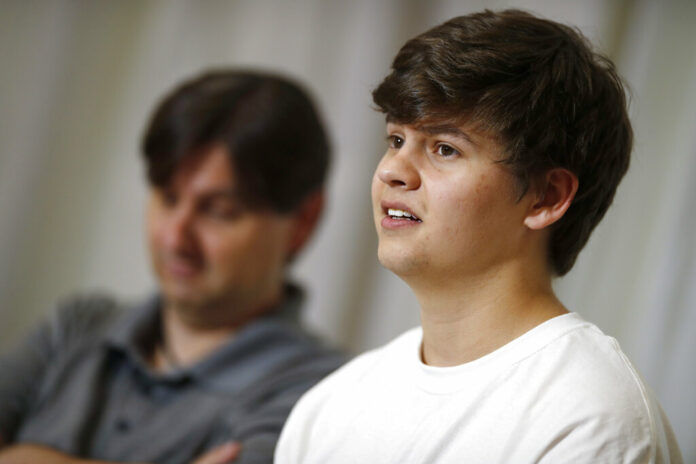 Joshua Jones, front, who was wounded while trying to stop a gunman involved in the attack on the STEM School Highlands Ranch last week, speaks during a news conference as his father, David, listens Tuesday, May 14, 2019, in Littleton, Colo. Photo: David Zalubowski / AP