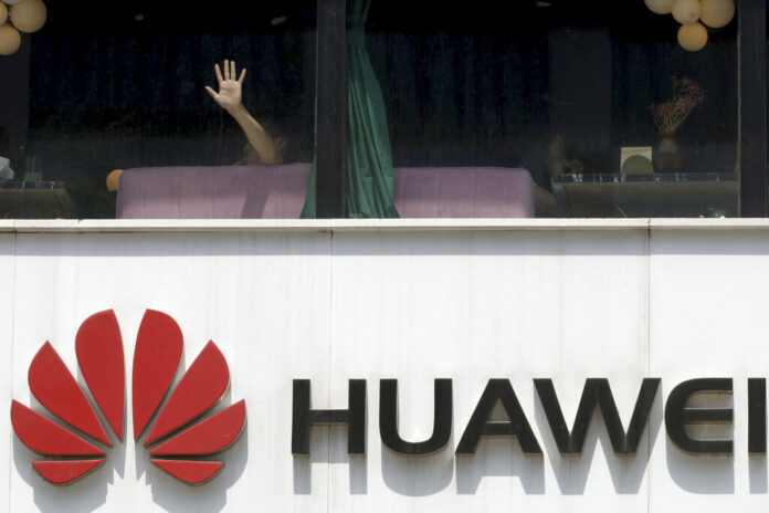A man presses on the glass window near a logo for Huawei in Beijing on Thursday, May 16, 2019. In a fateful swipe at telecommunications giant Huawei, the Trump administration issued an executive order Wednesday apparently aimed at banning its equipment from U.S. networks and said it was subjecting the Chinese company to strict export controls. Photo: Ng Han Guan / AP