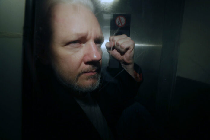In this May 1, 2019, file photo, WikiLeaks founder Julian Assange puts his fist up as he is taken from court in London. The Justice Department has charged Assange with receiving and publishing classified information. The charges are contained in a new, 18-count indictment announced May 23, 2019. Photo: Matt Dunham / AP In this May 1, 2019, file photo, WikiLeaks founder Julian Assange puts his fist up as he is taken from court in London. The Justice Department has charged Assange with receiving and publishing classified information. The charges are contained in a new, 18-count indictment announced May 23, 2019. Photo: Matt Dunham / AP