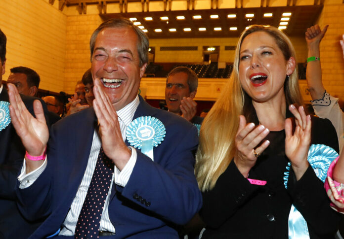 Brexit Party leader Nigel Farage, left, reacts as results are announced at the counting center for the European Elections for the South East England region, in Southampton, England, Sunday, May 26, 2019. Photo: Alastair Grant / AP