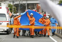 Man Stabs Kids at Japan Bus Stop; At Least 19 People Wounded Rescuers work at the scene of an attack in Kawasaki, near Tokyo Tuesday, May 28, 2019. A man wielding a knife attacked commuters waiting at a bus stop just outside Tokyo during Tuesday morning's rush hour, Japanese authorities and media said. Photo: Kyodo News via AP