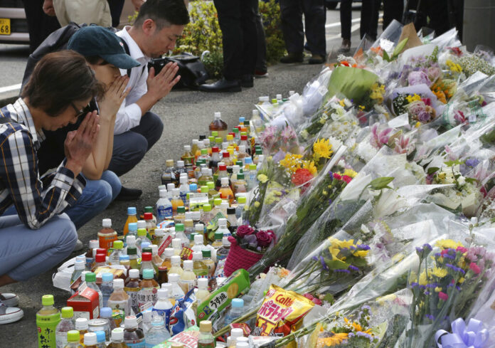 People pray for victims at the site where a knife attack took place in Kawasaki near Tokyo Wednesday, May 29, 2019. Photo: Koji Sasahara / AP