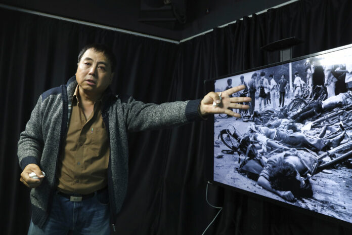 In this April 28, 2019, photo, Dong Shengkun gestures as he recalls being present at the scene seen in the photo when tanks ran down students taking part in the 1989 pro democracy protests during an interview in Beijing. Photo: Ng Han Guan / AP