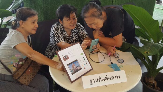 Elders learning how to use a photo editing app on their smartphones on March 29. Photo: Matichon Elders learning how to use a photo editing app on their smartphones on March 29. Photo: Matichon
