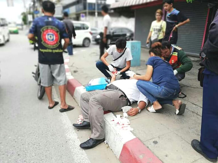 Rescue workers and bystanders come to activist Sirawith Seritiwat's aid on June 28, 2019, following an assault in Bangkok.