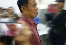 3 Thai Men Sentenced to Die for Killing British Man and Wife In this image made from Sept 25, 2018, video, murder suspect Warut Rattanasajjakit arrives at a police station for the murder his sister and her British husband in Prae Province, Thailand. Photo: AP
