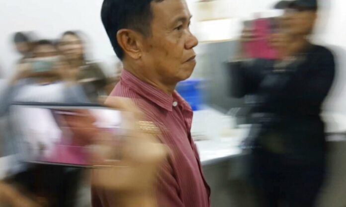 In this image made from Sept 25, 2018, video, murder suspect Warut Rattanasajjakit arrives at a police station for the murder his sister and her British husband in Prae Province, Thailand. Photo: AP