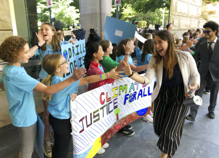 Kelsey Juliana, of Eugene, Ore., a lead plaintiff who is part of a lawsuit by a group of young people who say U.S. energy policies are causing climate change and hurting their future, greets supporters outside a federal courthouse Tuesday, June 4, 2019, in Portland, Ore. Photo: Andrew Selsky / AP Kelsey Juliana, of Eugene, Ore., a lead plaintiff who is part of a lawsuit by a group of young people who say U.S. energy policies are causing climate change and hurting their future, greets supporters outside a federal courthouse Tuesday, June 4, 2019, in Portland, Ore. Photo: Andrew Selsky / AP