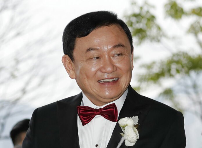 FILE - In this Friday, March 22, 2019 file photo, Former Thai Prime Minister Thaksin Shinawatra welcomes his guests for the wedding of his youngest daughter Paetongtarn 