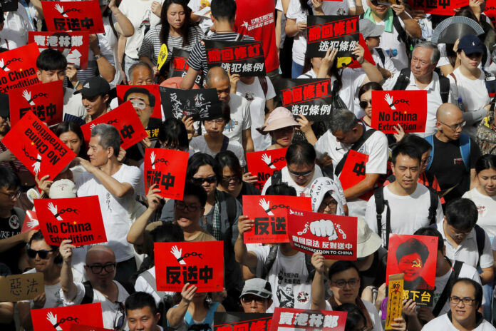 Protesters hold placards march in a rally against the proposed amendments to extradition law in Hong Kong, Sunday, June 9, 2019. The amendments have been widely criticized as eroding the semi-autonomous Chinese territory's judicial independence by making it easier to send criminal suspects to mainland China, where they could face vague national security charges and unfair trials. Photo: Kin Cheung / AP