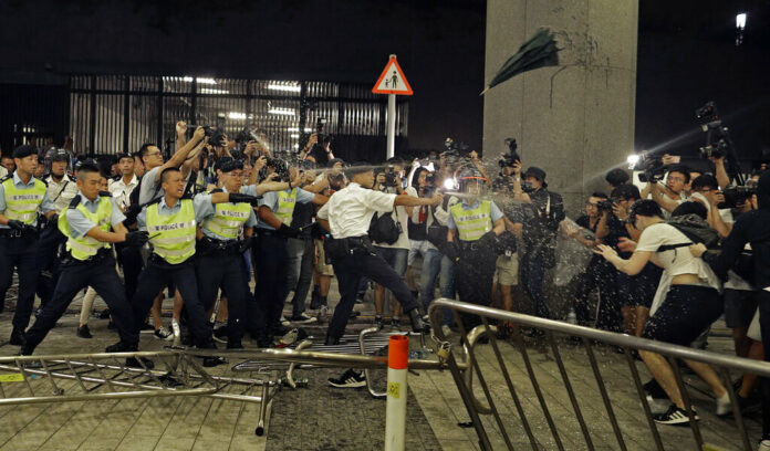 Police officers use pepper spray against protesters in a rally against the proposed amendments to the extradition law at the Legislative Council in Hong Kong during the early hours of Monday, June 10, 2019. The extradition law has aroused concerns that this legislation would undermine the city's independent judicial system as it allows Hong Kong to hand over fugitives to the jurisdictions that the city doesn't currently have an extradition agreement with, including mainland China, where a fair trial might not be guaranteed. Photo: Vincent Yu / AP