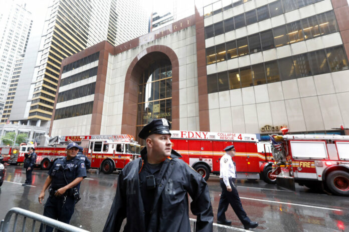 New York City Police and Fire Department personnel secure the scene in front of a building in midtown Manhattan where a helicopter crash landed, Monday, June 10, 2019. The Fire Department says the helicopter crash-landed on the top of the tower, which isn't far from Rockefeller Center and Times Square. Photo: Richard Drew / AP