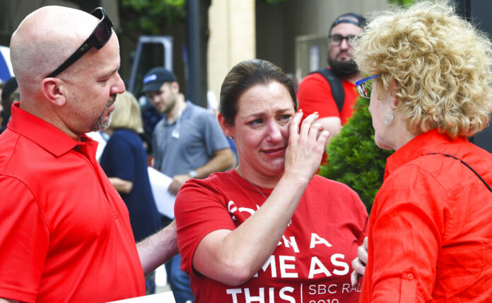 Jules Woodson, center, of Colorado Springs, Colo., is comforted by her boyfriend Ben Smith, left, and Christa Brown while demonstrating outside the Southern Baptist Convention's annual meeting Tuesday, June 11, 2019, in Birmingham, Ala. First-time attendee Woodson spoke through tears as she described being abused sexually by a Southern Baptist minister. Photo: Julie Bennett / AP