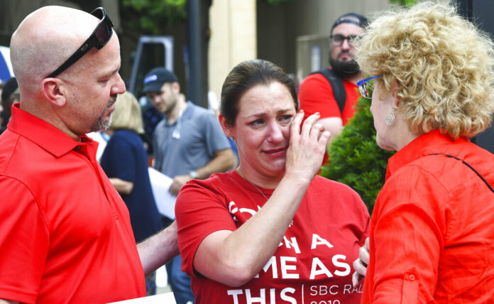 Jules Woodson, center, of Colorado Springs, Colo., is comforted by her boyfriend Ben Smith, left, and Christa Brown while demonstrating outside the Southern Baptist Convention's annual meeting Tuesday, June 11, 2019, in Birmingham, Ala. First-time attendee Woodson spoke through tears as she described being abused sexually by a Southern Baptist minister. Photo: Julie Bennett / AP Jules Woodson, center, of Colorado Springs, Colo., is comforted by her boyfriend Ben Smith, left, and Christa Brown while demonstrating outside the Southern Baptist Convention's annual meeting Tuesday, June 11, 2019, in Birmingham, Ala. First-time attendee Woodson spoke through tears as she described being abused sexually by a Southern Baptist minister. Photo: Julie Bennett / AP