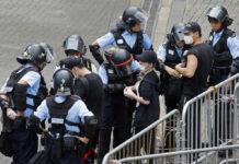 Hong Kong Quiet Now, but Prospect of New Protest Looms Large Riot police check the bags of protesters outside the Legislative Council in Hong Kong, Thursday, June 13, 2019. After days of silence, Chinese state media is characterizing the largely peaceful demonstrations in Hong Kong as a "riot" and accusing protesters of "violent acts." Photo: Kin Cheung