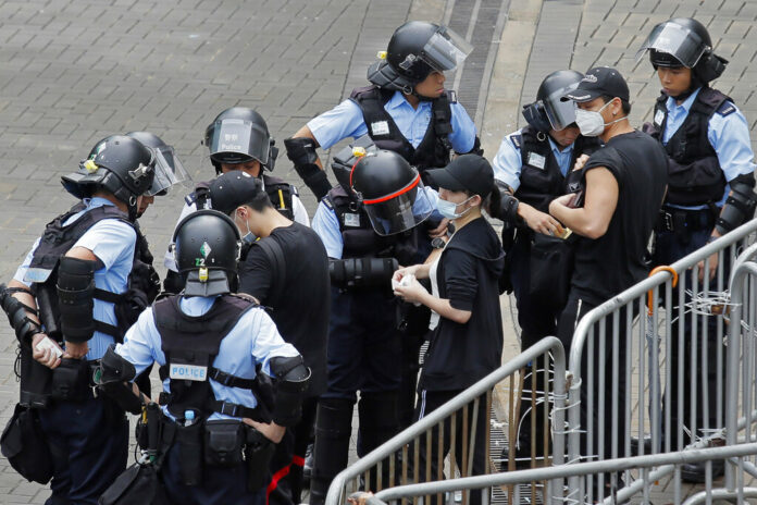 Riot police check the bags of protesters outside the Legislative Council in Hong Kong, Thursday, June 13, 2019. After days of silence, Chinese state media is characterizing the largely peaceful demonstrations in Hong Kong as a 