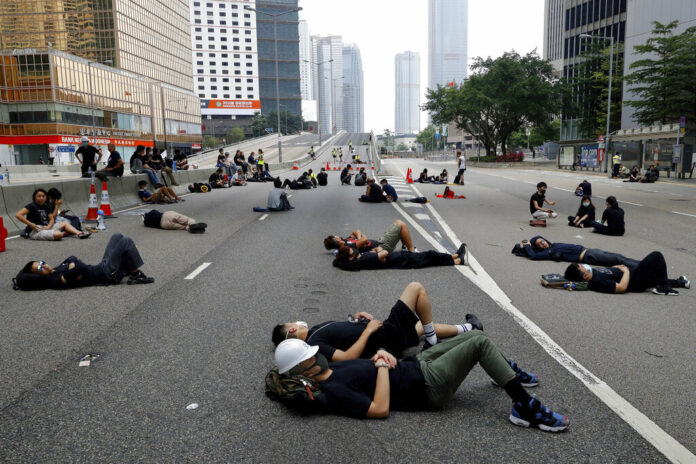 Protesters who camped out overnight take a rest along a main road near the Legislative Council after continuing protest against the unpopular extradition bill in Hong Kong, Monday, June 17, 2019. Hong Kong police and protesters faced off Monday as authorities began trying to clear the streets of a few hundred who remained near the city government headquarters after massive demonstrations that stretched deep into the night before. Photo: Vincent Yu / AP