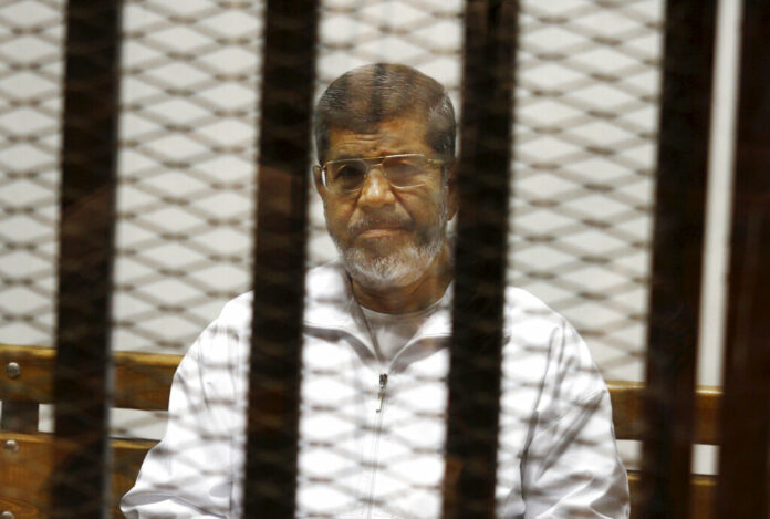 FILE - In this May 8, 2014 file photo, Egypt's ousted Islamist President Mohammed Morsi sits in a defendant cage in the Police Academy courthouse in Cairo, Egypt. On Monday June 17, 2019, Egypt's state TV said the country's ousted President Mohammed Morsi, 67, collapsed during a court session and died. It said it occurred while he was attending a court trial on espionage charges. Morsi, who hailed from Egypt's largest Islamist group, the now outlawed Muslim Brotherhood, was elected president in 2012 in the country's first free elections following the ouster the year before of longtime leader Hosni Mubarak. Photo: Tarek el-Gabbas / AP