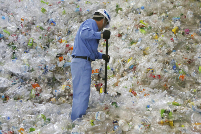 In this June 18, 2019, photo, a plastic recycling company worker sorts out plastic bottles collected for processing at Tokyo Petbottle Recycle Co., Ltd, in Tokyo. Photo: Koji Sasahara / AP