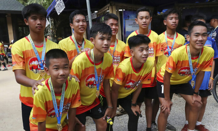 Members of the Wild Boars soccer team who were rescued from a flooded cave, pose for the media after a marathon and biking event in Mae Sai, Chiang Rai province, Thailand, Sunday, June 23, 2019. Some of the 12 young Thai soccer players and their coach have marked the anniversary of their ordeal that saw them trapped in a flooded cave for two weeks with a commemorative marathon in northern Thailand. Photo: Sakchai Lalit / AP