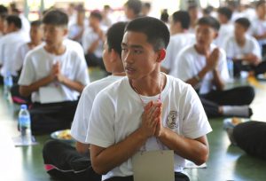 In this Saturday, June 22, 2019, photo, Adul Sam-on, a member of the Wild Boars soccer team who were rescued from a flooded cave last year, pray during The Dharma Life Improvement Camp in Mae Sai, Chiang Rai province, northern Thailand. Some of the 12 young Thai soccer players and their coach have marked the anniversary of their ordeal that saw them trapped in a flooded cave for two weeks with a commemorative marathon in northern Thailand. Photo: Sakchai Lalit / AP