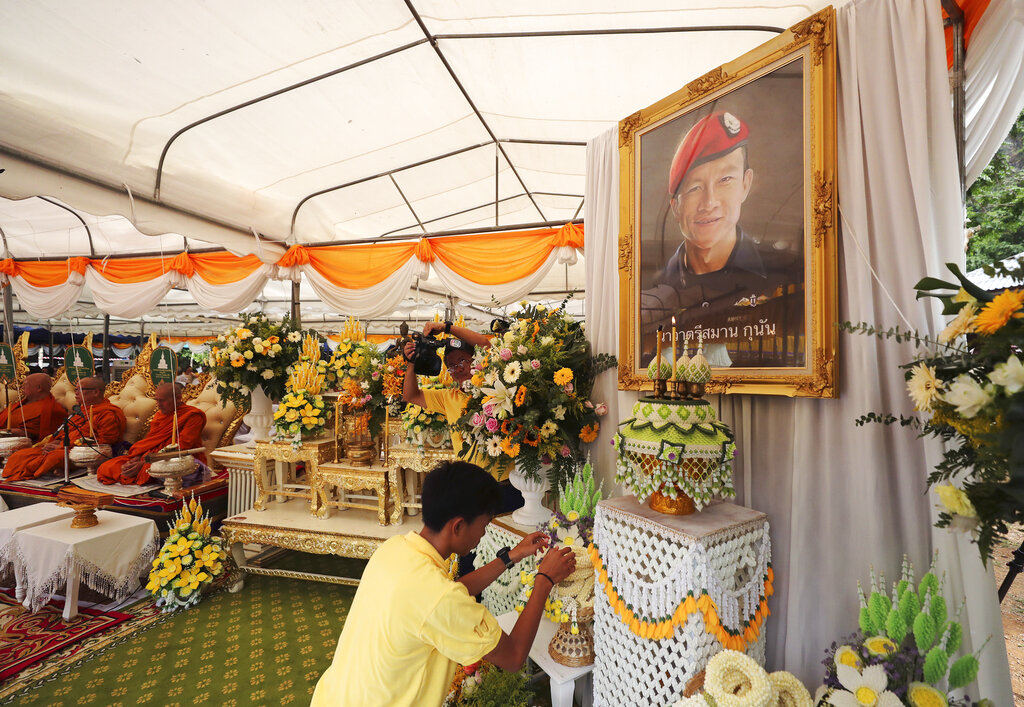 Nattawut Takamrong, a member of the Wild Boars soccer team who were rescued from a flooded cave, pays respect in front of a portrait of Saman Gunan, the retired Thai SEAL diver who died during the rescue mission, near the Tham Luang cave in Mae Sai, Chiang Rai province, Thailand Monday, June 24, 2019. Photo: Sakchai Lalit / AP