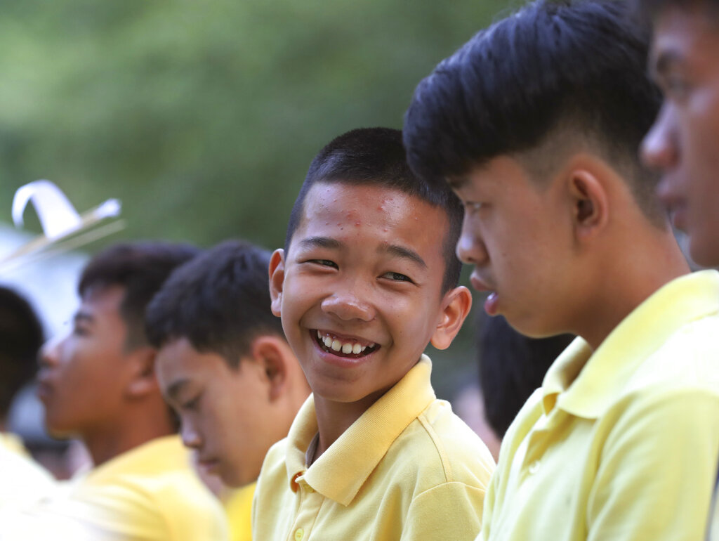 Chanin Vibulrungruang, center, talks to Pornchai Kamluang, right, both are members of the Wild Boars soccer team who were rescued from a flooded cave, before a religious ceremony at Tham Luang in Mae Sai, Chiang Rai province, Thailand Monday, June 24, 2019. Photo: Sakchai Lalit / AP