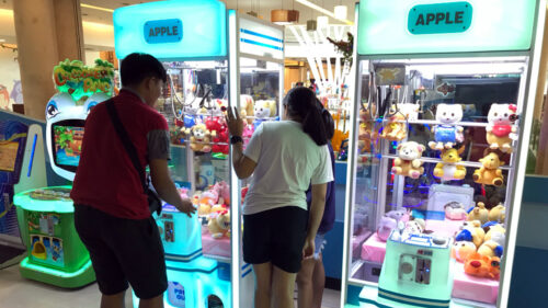 Players try to grab prizes using claw machines at a Chiang Mai shopping mall on June 16.