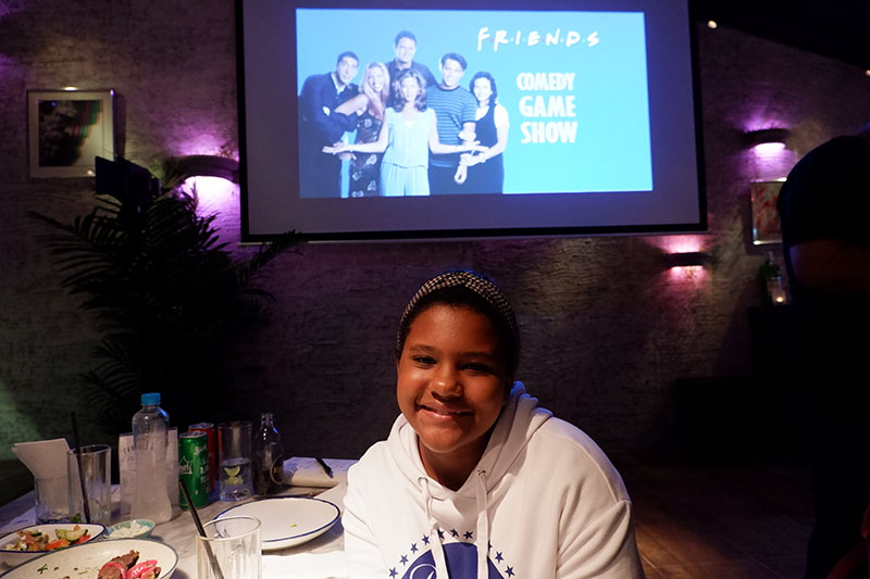 Myla Reis de Soaza, a 10-year-old Brazilian-Indian and sixth grader at St. Andrews International School, came to the trivia night with her family, including grandma Latmi Dialdas, 64. She’s watched the entire show 16 times, she says. Other than the humor, friendships, and her favorite character Joey, the show has given her a glimpse into ‘90s tech. “I didn’t know you could make calls from that kind of telephone,” she said, referring to a home phone. “There were also those flip phones, and in one episode Phoebe pulled out a really big phone from her purse.” 