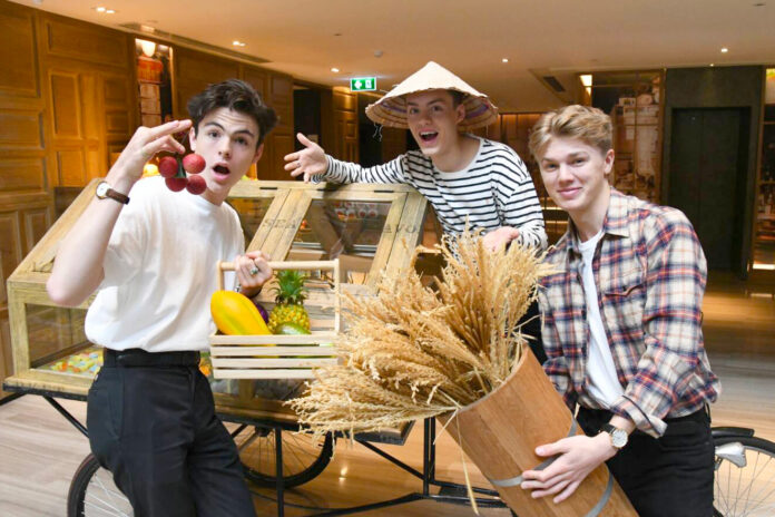 Blake Richardson, Reece Bibby, and George Smith of New Hope Club play with Thai food props at an interview on June 10, 2019 in Bangkok.