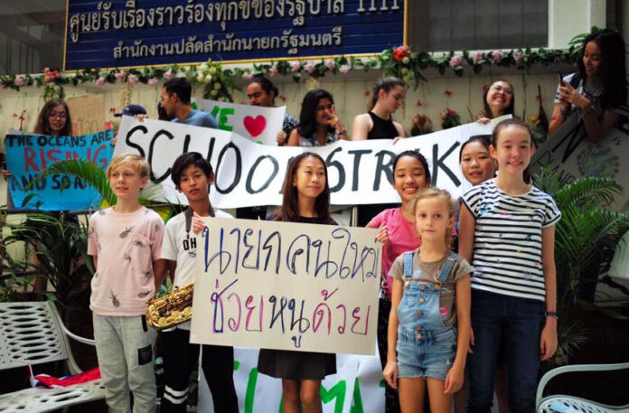 Lilly with her friends hold up signs March 15 at the Prime Minister's Office.