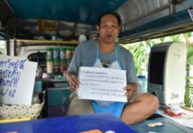 Price Hike at Coffee Truck Because Prayuth Is PM Wanchai holding the viral sign on June 11.